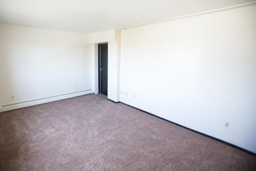 An empty room with carpet and white walls.