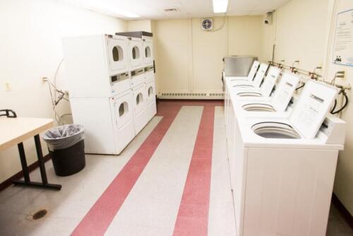 A laundry room with several washers and dryers.