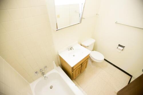 A bathroom with a toilet, sink and tub.