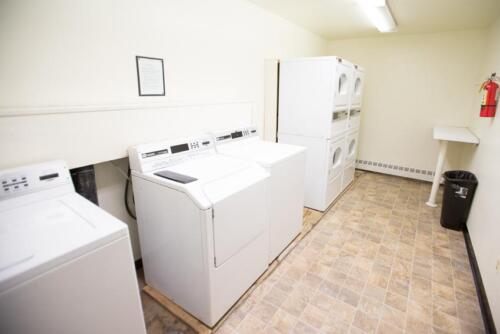 A laundry room with several washers and dryers.